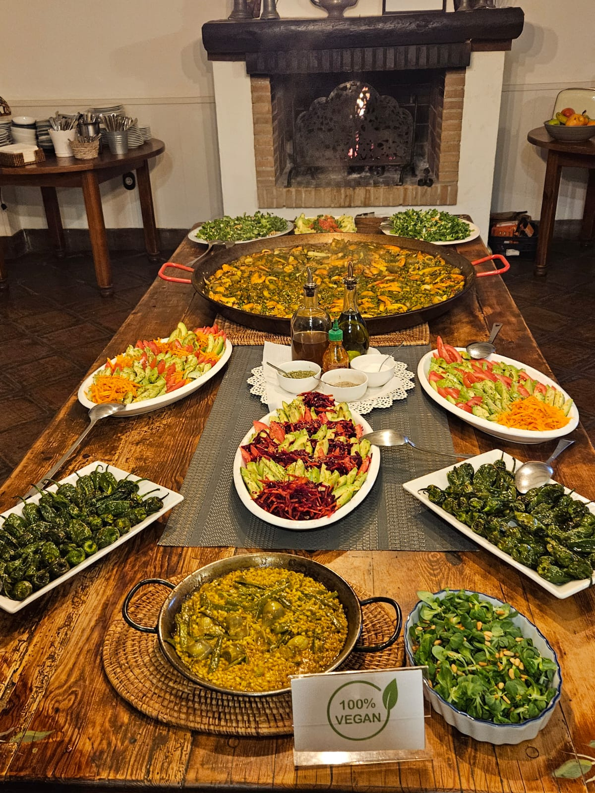 a buffet spread of paella and salads on a wooden table