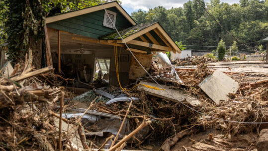 A destroyed house sits amid debris in Chimney Rock, NC after Hurricane Helene.