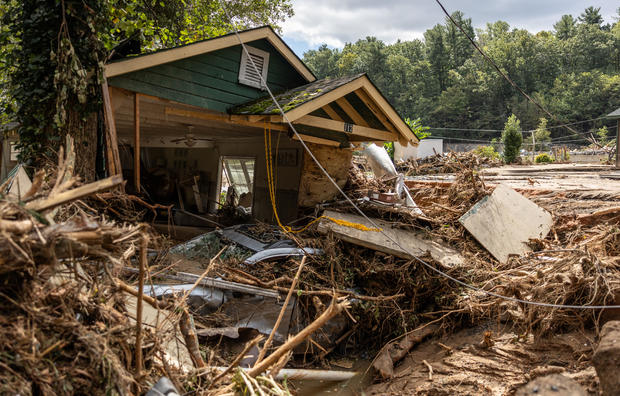 A destroyed house sits amid debris in Chimney Rock, NC after Hurricane Helene.