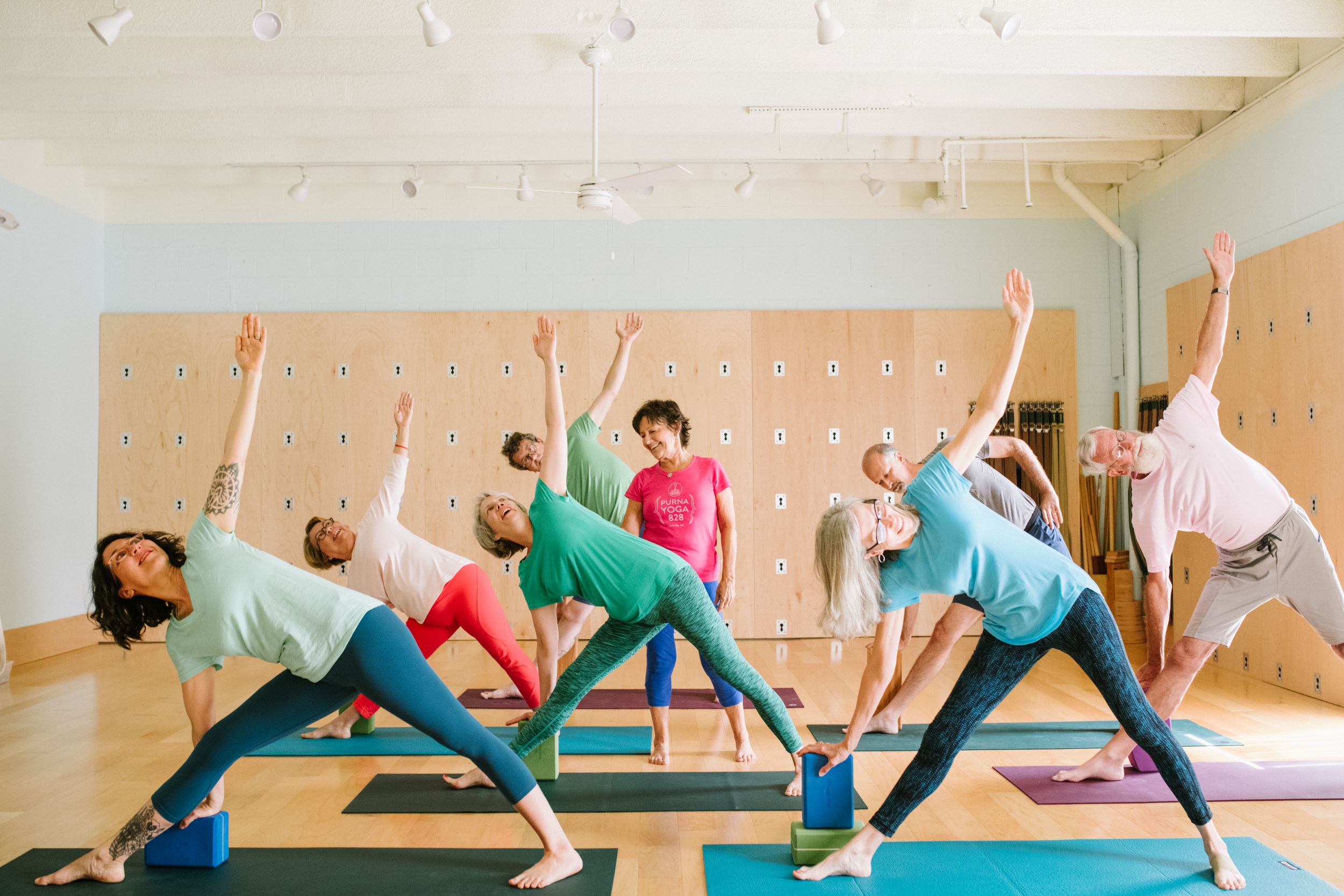 A photo of Letitia teaching students Trikonasana (Triangle pose).